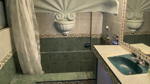 Un baño con bañera, lavamanos y ducha.