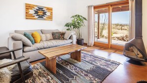 A living room with a sofa, coffee table, and a fireplace. - 🌵MoonView Modern | Hot tub, BBQ & Private Pool🌵 (Joshua Tree)