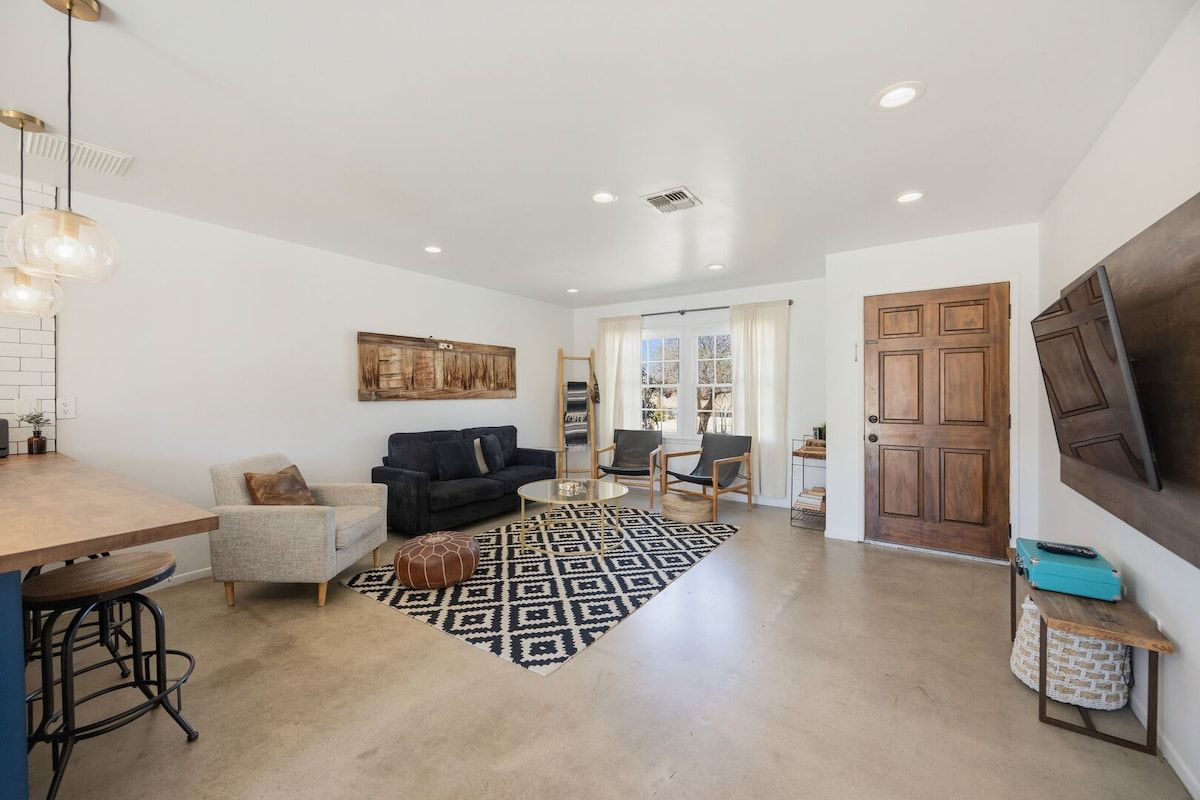 A spacious living area with a sofa, chairs, a coffee table, and a patterned rug.