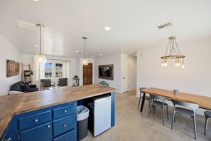 A modern kitchen with a wooden island, blue cabinets, and a built-in mini-fridge. - Cosmic Rabbit - Family Friendly home w/Hot Tub (Joshua Tree)