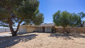 A house with a garage, a covered patio, and a fenced yard. - Cosmic Rabbit - Family friendly home w/Hot Tub (Joshua Tree)