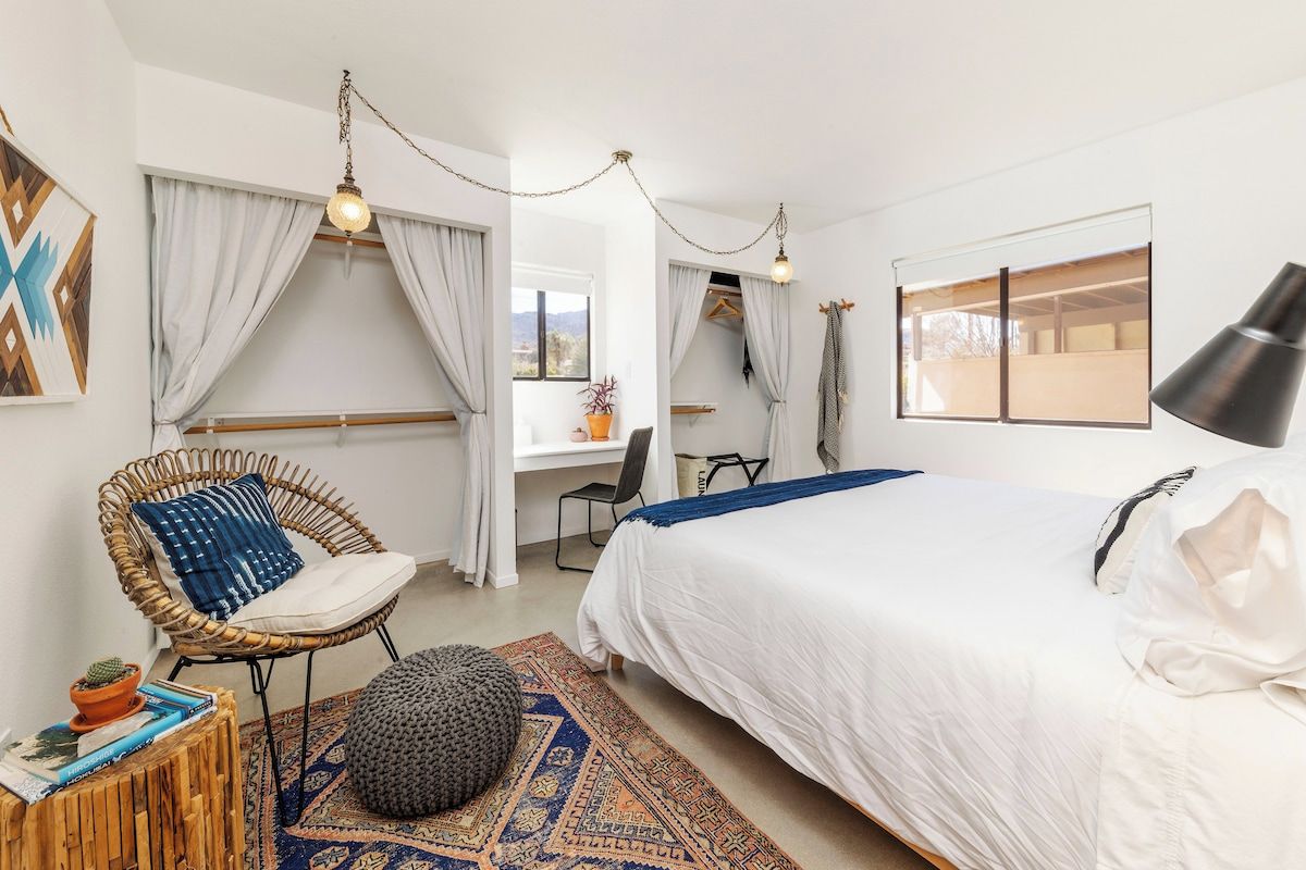 Une chambre à coucher avec un lit, une chaise, un bureau et une fenêtre.