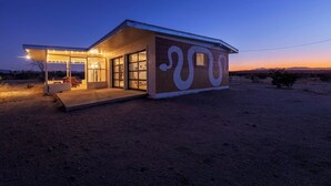 Une maison moderne dotée d’une grande fenêtre et d’un porche abrité.