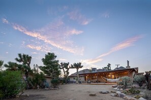 A desert-style house with a spacious outdoor area, including a hammock and a patio.