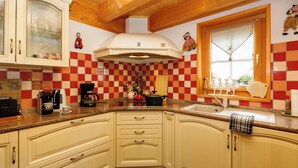 Una cucina con zoccolo di piastrelle a scacchi, una macchina per il caffè e una finestra con vista.