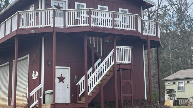 Ein zweistöckiges Gebäude mit Balkon, Treppe und einer Tür mit Sterndekoration.