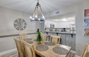 Enjoy cooking in this well-equipped kitchen with a microwave, oven, and refrigerator, and dine at the wooden dining table.