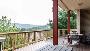 A wooden deck with a railing, a table, and chairs. - SLOPESVIEW 4,400sq ft ~ 3 Level Home~ 6 BR,4BA, Sleeps 16~ Games!Walk to slopes! (Lake Harmony)