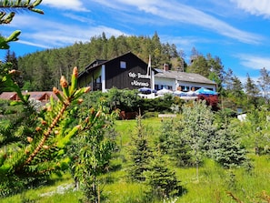 A lodge with a large sign reading 'Cafe Pension Kemps' surrounded by lush greenery and trees. - Café-Pension Krems - Double room (Waischenfeld-Heroldsberg-Tal)