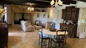 A cozy living room with a fireplace, comfortable seating, and a dining area.
