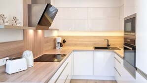 Een moderne keuken met een inbouwoven, een koffiezetapparaat en een broodrooster.