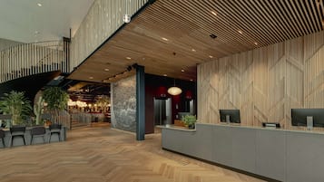 A spacious lobby with a wooden ceiling, a reception desk, and a staircase.
