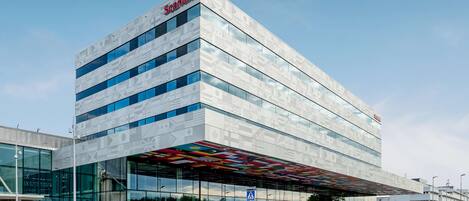 A modern building with a glass facade and a distinctive patterned roof.