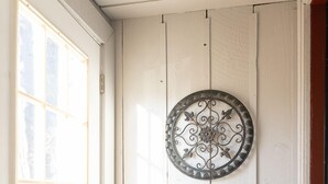 A white door with a decorative metal plate, a wooden floor, and a window with a grid pattern. - In the Heart of the Sandhills (Aberdeen)