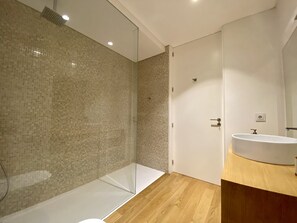 Enjoy a refreshing shower in the sleek bathroom with a glass-enclosed shower area and modern vanity.