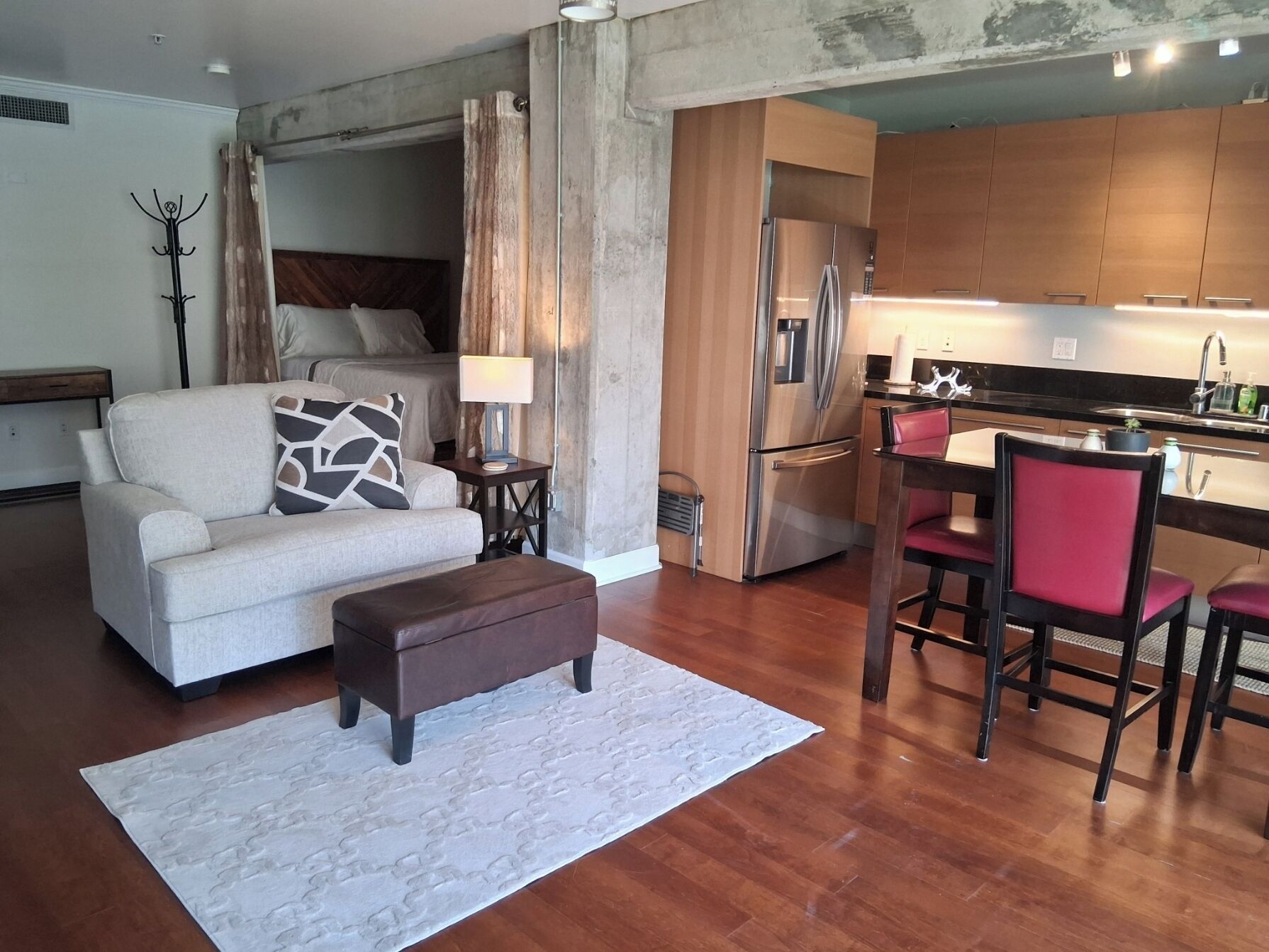A modern living room with a sofa, a coffee table, and a dining area with chairs.