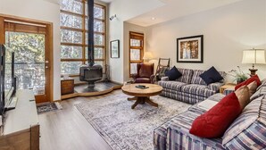 A cozy living room with a fireplace, a sofa set, a coffee table, and a television.