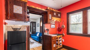 A kitchen with wooden cabinets, a black refrigerator, and a window with blinds. - Tremont - 2BR apt - Pet Friendly, Convenient to Stadiums, Clinic, Museums & more (Cleveland)