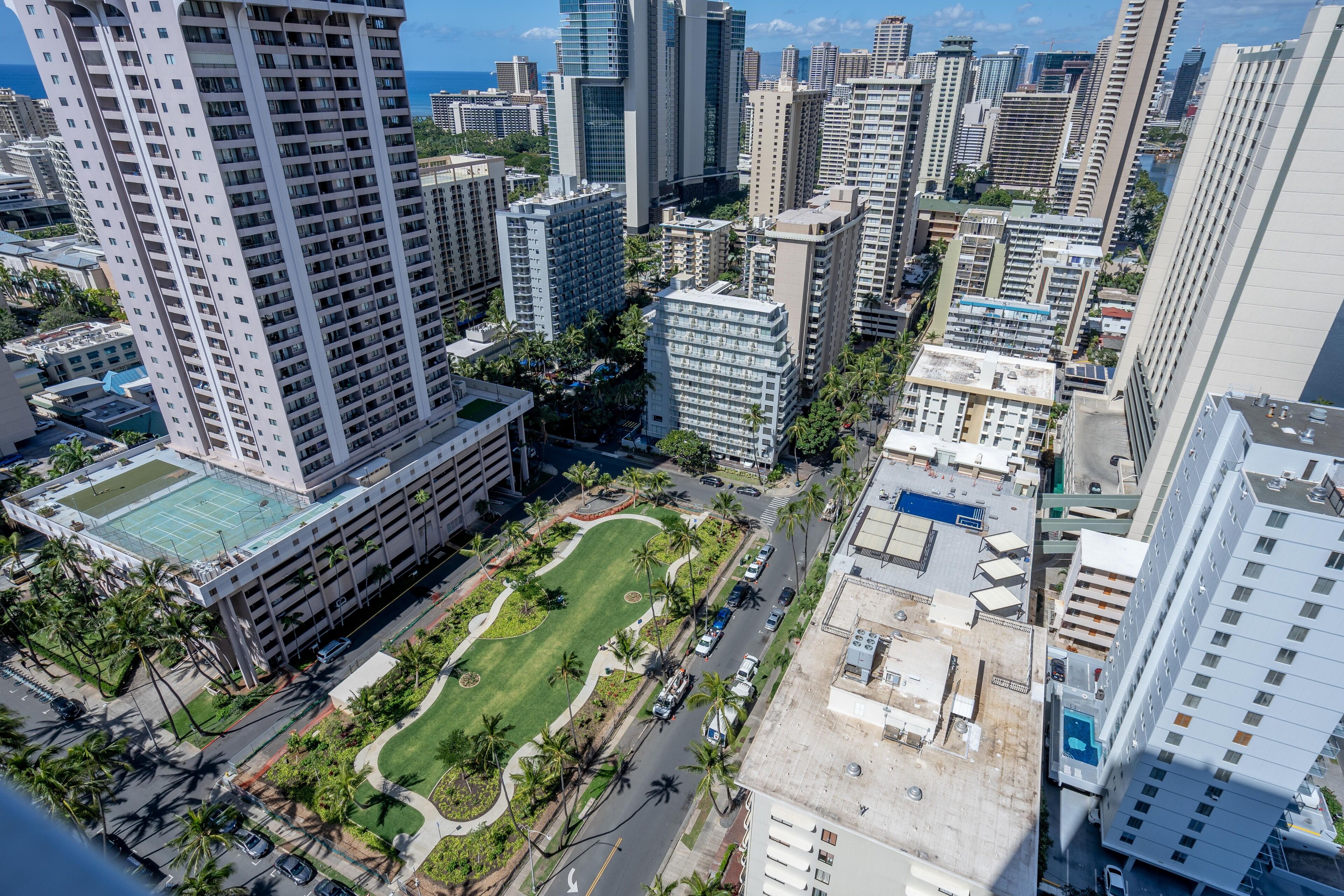 A high-rise building with a rooftop garden and parking area.