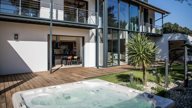 A modern two-story house with a wooden deck, a hot tub, and a balcony. - Beautiful contemporary villa between lake and ocean. Free wifi. (Soorts-Hossegor)