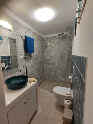 A bathroom with patterned tiles, a sink, a toilet, and a shower. - Blue Paradise: Comfy Beach Villa walking distance to the sea / pool access (Paros)