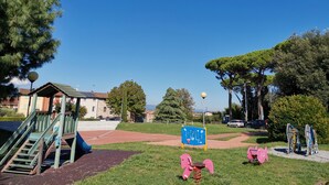 A playground with a slide, climbing structure, and exercise equipment. - Villetta Camelia with private parking just a stone's throw from Lucca (Capannori)