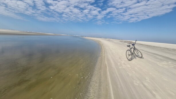 A bicycle parked on a sandy beach with a clear sky. - Beach house: 5 bedrooms, swimming pool, barbecue, billiards. Excellent location. (Bertioga)