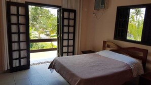 A bedroom with a bed, a window, and a view of greenery outside. - Beach house: 5 bedrooms, swimming pool, barbecue, billiards. Excellent location. (Bertioga)