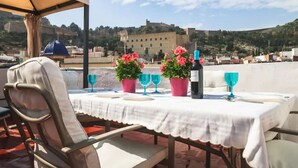 A table set outdoors with a white tablecloth, pink flowers, blue wine glasses, and a bottle. - SPACIOUS HOUSE IN HISTORIC CENTER WITH MAGNIFICENT VIEWS (Sagunt)