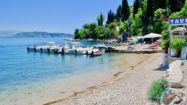 A beachside tavern with boats docked, a pebble beach, and cypress trees. - Villa Eva Agni with private pool (Agni)