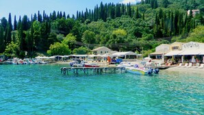 A coastal area with boats docked at a pier, surrounded by lush greenery and a hillside. - Villa Eva Agni with private pool (Agni)