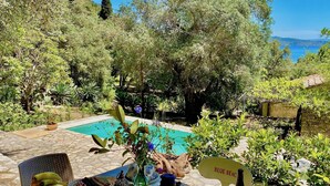 A poolside table with fruits, a bottle of wine, and a lantern. - Villa Eva Agni with private pool (Agni)
