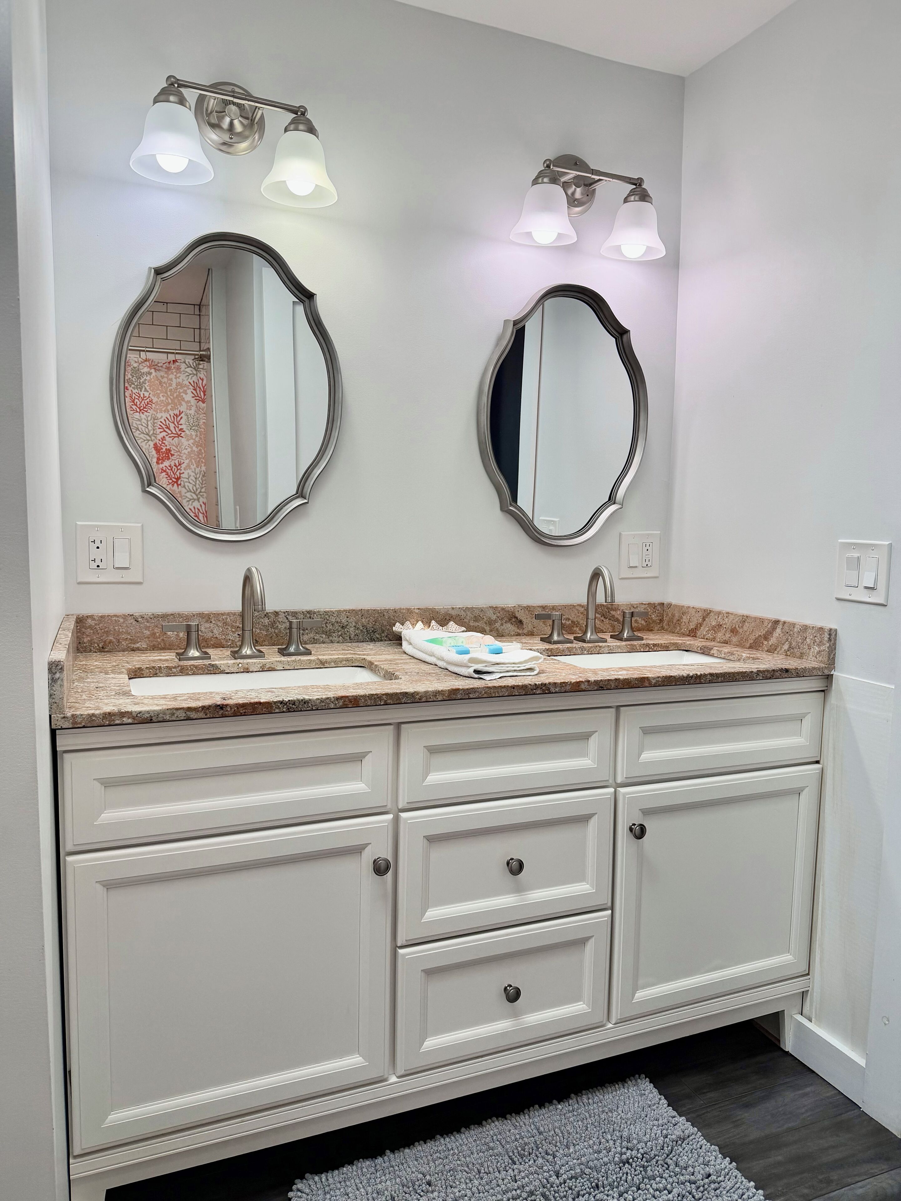 A bathroom with two sinks, a mirror, and a towel rack.