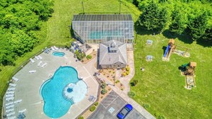 Vista aérea de um resort com piscina, um pavilhão coberto e estacionamento.