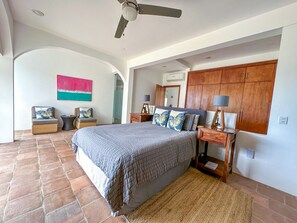 A bedroom with a large bed, wooden wardrobe, and a ceiling fan. - Ocean Front Surfing Bocana Beach Villa Nena Rubio pool near golf (Bahias de Huatulco)