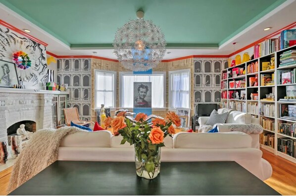 A living room with a fireplace, a sofa, a coffee table, and a bookshelf.