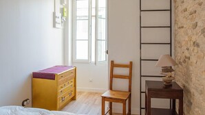 A bedroom with a bunk bed, a wooden chair, a small table with a lamp, and a dresser. - Small renovated house with terrace in the heart of St Pierre d'Oléron (Saint Pierre d'Oléron)