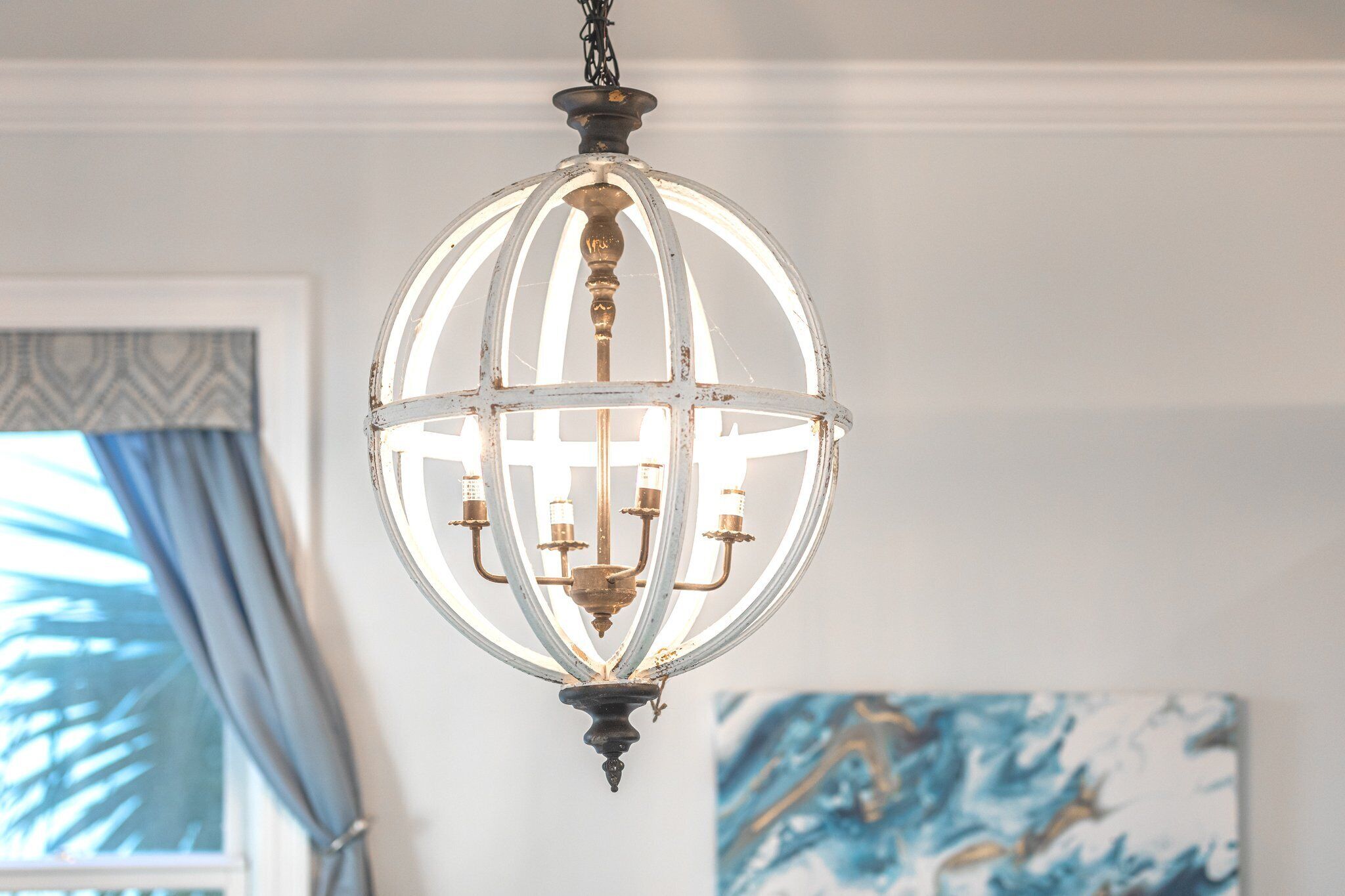 A chandelier with a white, ornate design hanging from the ceiling.