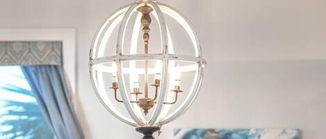 A chandelier with a white, ornate design hanging from the ceiling.
