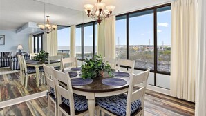 Un coin repas avec une table ronde, des chaises et un lustre.