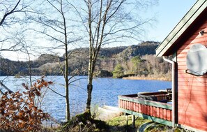 Escape to a serene lakeside retreat with a tranquil view of the surrounding hills and calm lake.