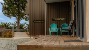 A wooden deck with two chairs and a sign reading "Star Bright" and "Star Light". - The Starlight Townhouse (Twizel)