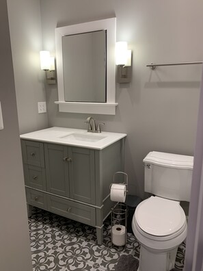 Een bad/douchecombinatie, een haardroger, handdoeken, zeep