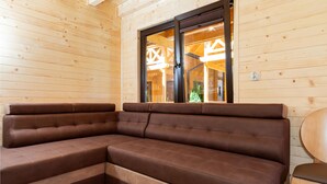 A corner sofa in a wooden cabin with a large window. - Nice home in Pobierowo with WiFi (Pobierowo)