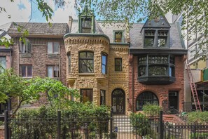 A row of Victorian-style buildings with distinct architectural features such as bay windows and ornate detailing.