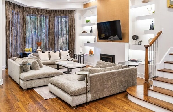 TV connectée, cheminée, livres, médiathèque