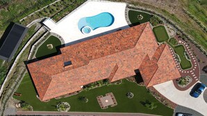 An aerial view of a building with a red-tiled roof, a swimming pool, and surrounding landscaped areas. - Casita at Vista Del Paraiso-Incredable central valley view (Atenas)