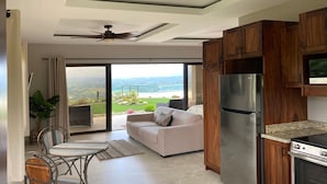 A modern kitchen with wooden cabinets, a stainless steel refrigerator, and a built-in oven. - Casita at Vista Del Paraiso-Incredable central valley view (Atenas)