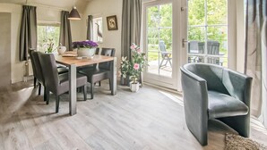 A dining area with a wooden table, grey chairs, and potted plants. - Stunning home in Den Ham with WiFi (Den Ham)