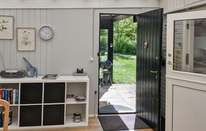 Ein Zimmer mit Bücherregal, einer Uhr und einer Tür, die nach draußen führt.